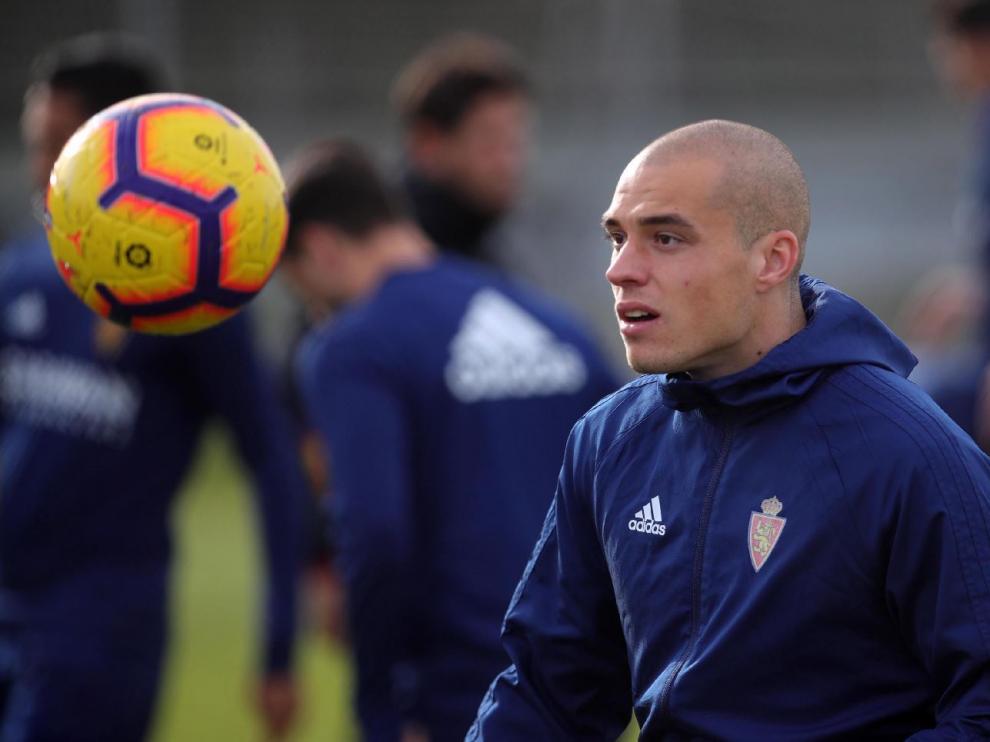 Pombo juega con el balón en el entrenamiento de este viernes. Detrás, difuminados en el enfoque, Gual y Vázquez.