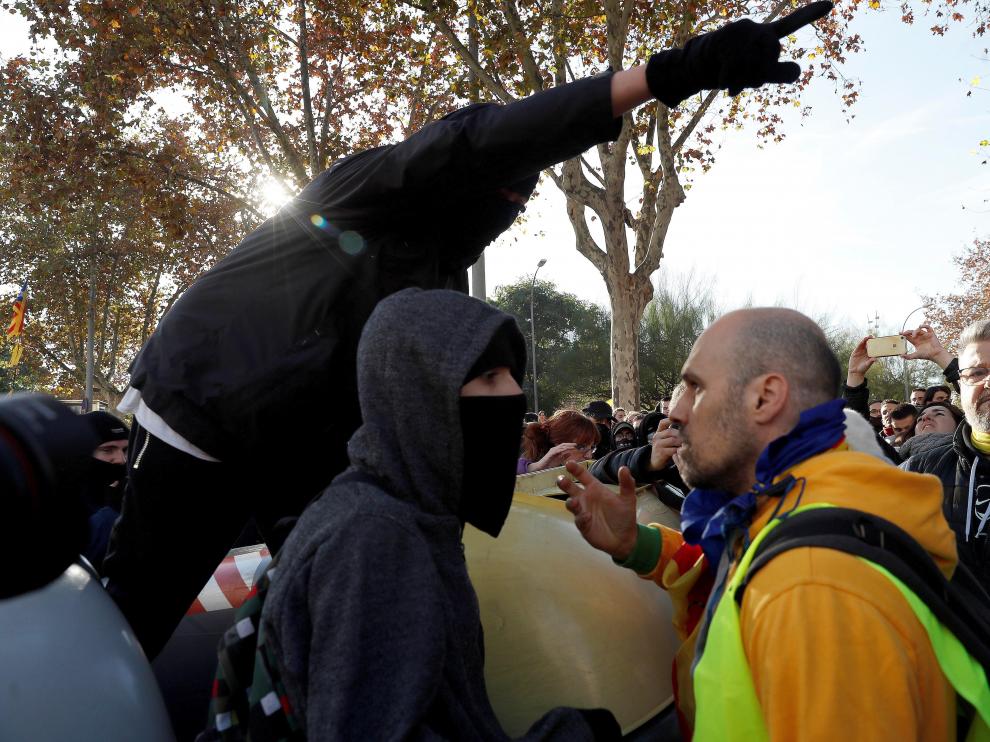 Un grupo de manifestantes trata de atravesar el cordón policial y otros tratan de impedirlo.