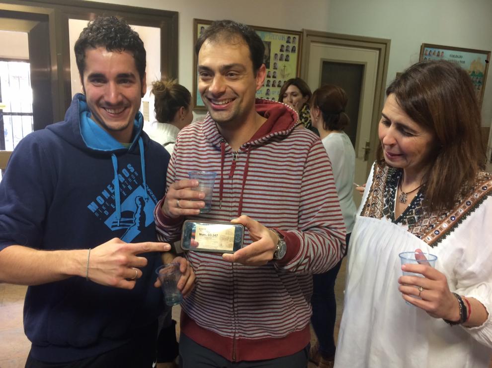 Joan Guardia enseña el móvil con una imagen de una de las participaciones agraciadas
