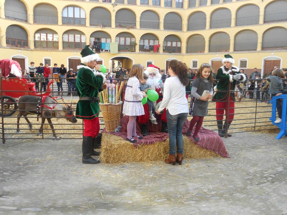 Mientras los renos descansaban, Papa Noel se ha sacado fotos con niños y mayores en la plaza de Toros Vieja