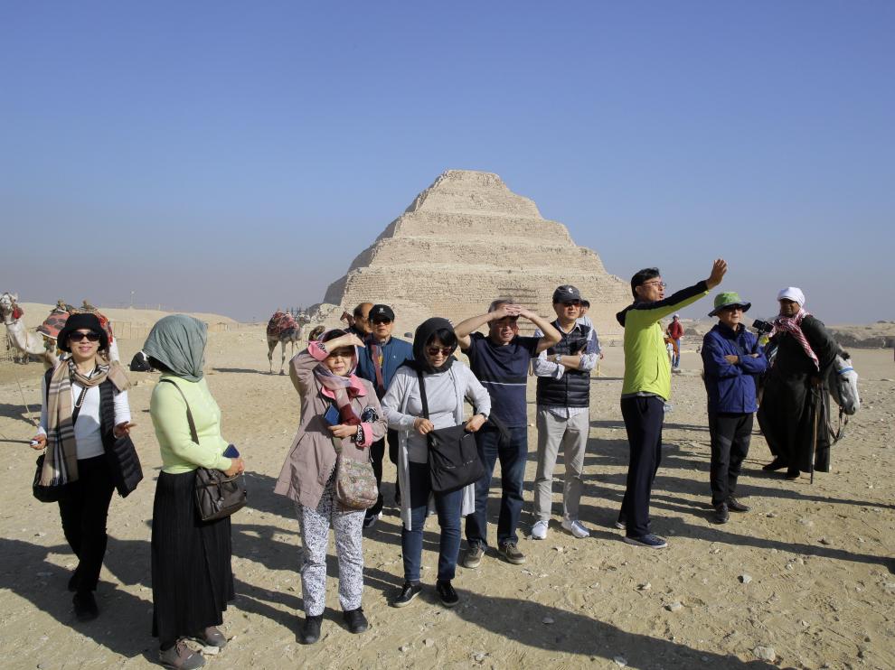 Un grupo de turistas fotografía las pirámides en Guiza (Egipto).