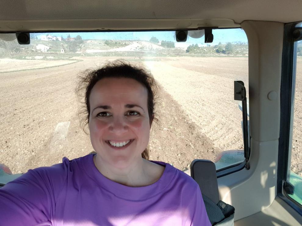 María Ángeles Rosado, joven agricultora y madre, sonríe desde su tractor.