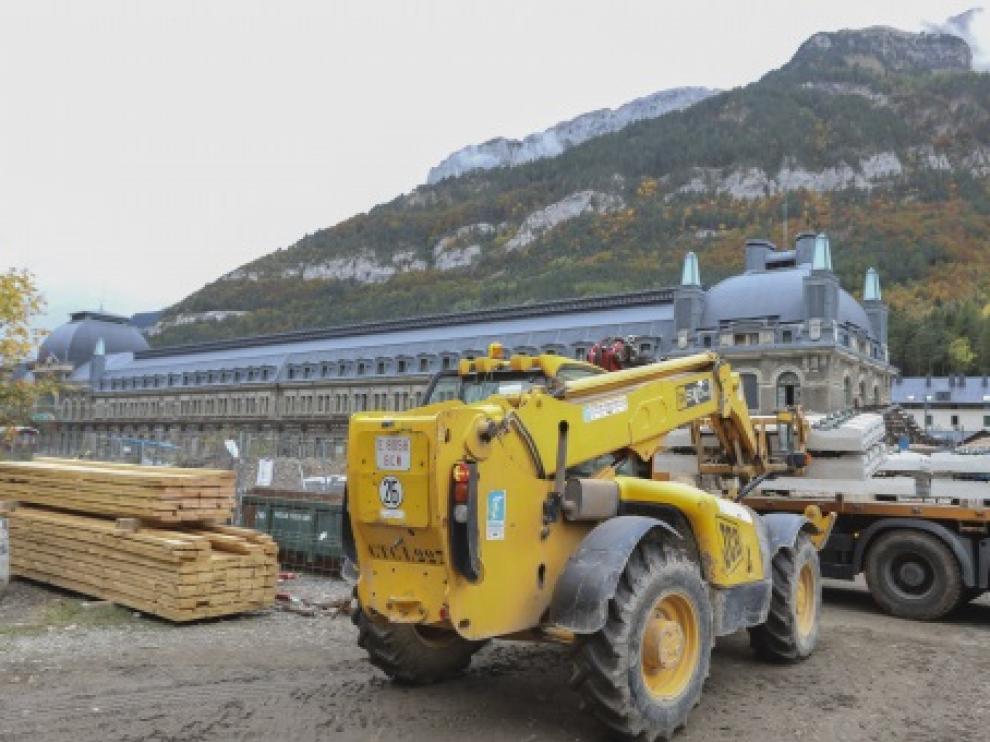 Una grúa descarga vías y balasto para colocarla en la explanada de la estación de Canfranc