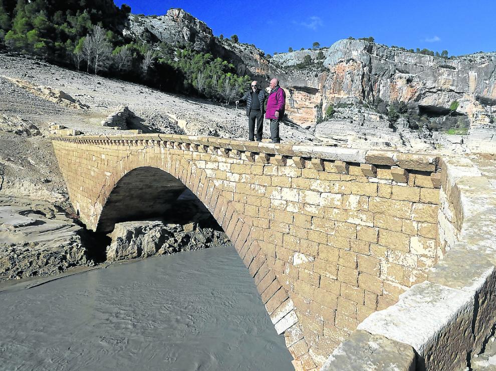 Perdiguer (izda.), antiguo vecino de Santolea, junto a un familiar en el puente aflorado.