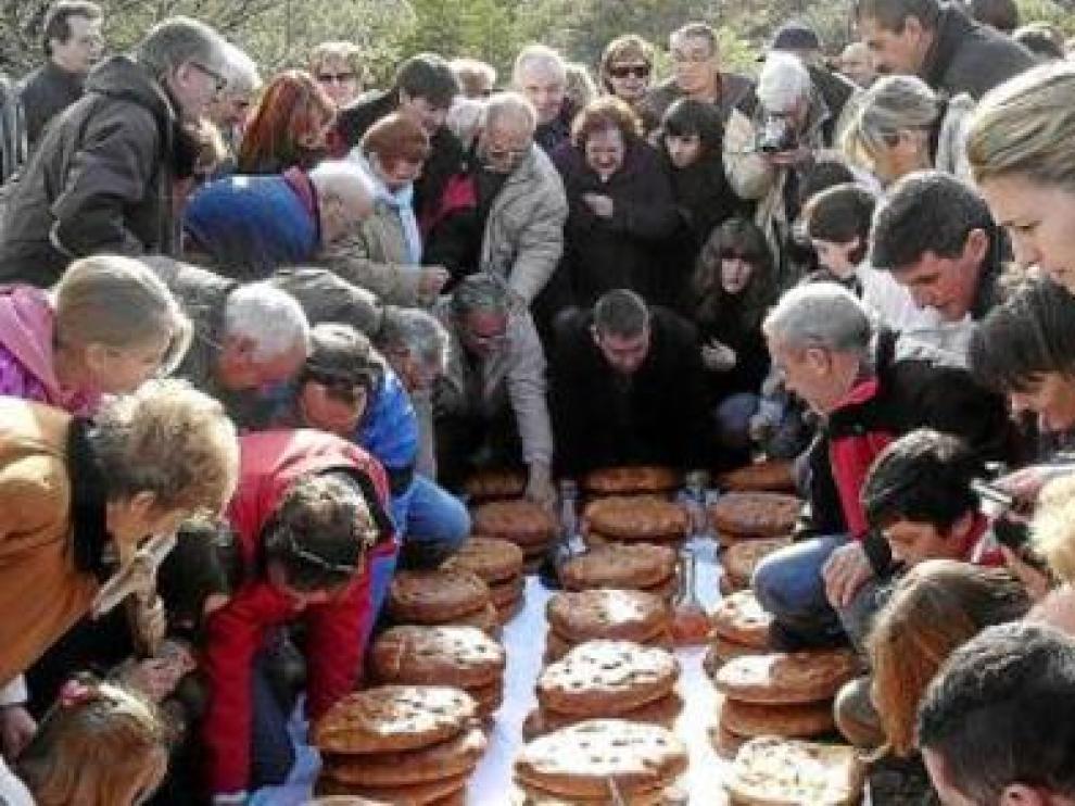 Los participantes en la romería buscan los langostos para ver el color que predice las cosechas