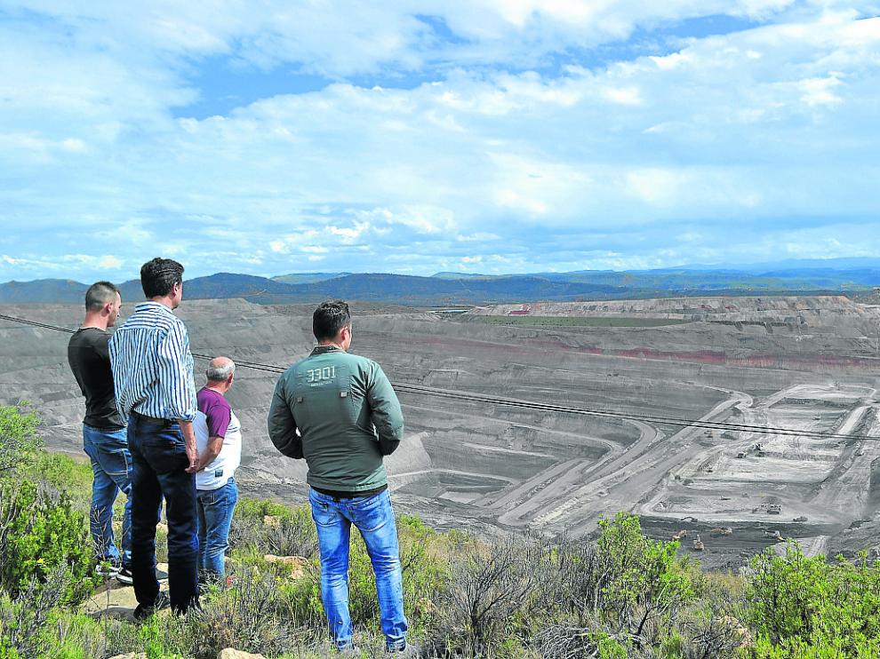 El alcalde de Ariño, Joaquín Noé, y un grupo de trabajadores observan la mina que se cierra