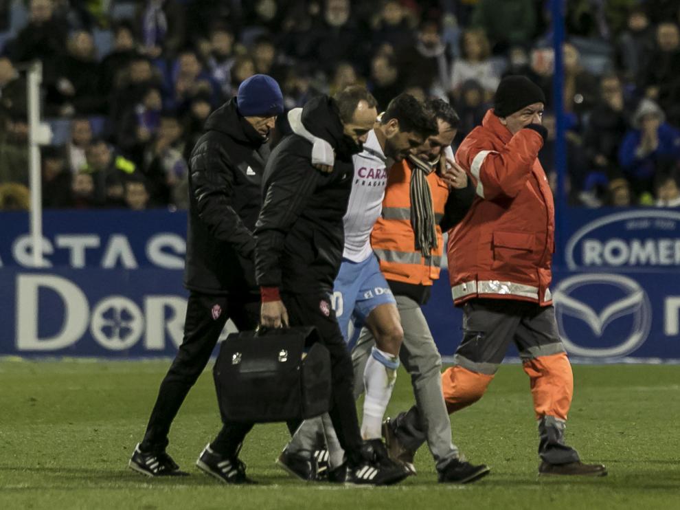 Javi Ros se retira acompañado de las asistencia, del doctor Honorio Martínez y de Míchel Román, masajista y fisio del primer equipo.