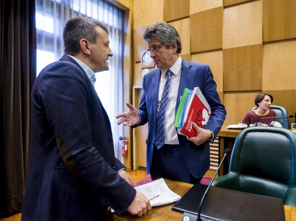 El concejal de Economía, Fernando Rivarés, conversa con el edil del PSOE Javier Trívez, en el salón de plenos del Ayuntamiento de Zaragoza.