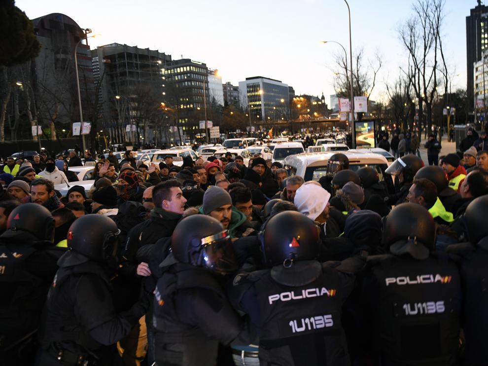 Agentes de la Policía Nacional desalojan a los taxistas que permanecen acampados desde este sábado en el Paseo de la Castellana.
