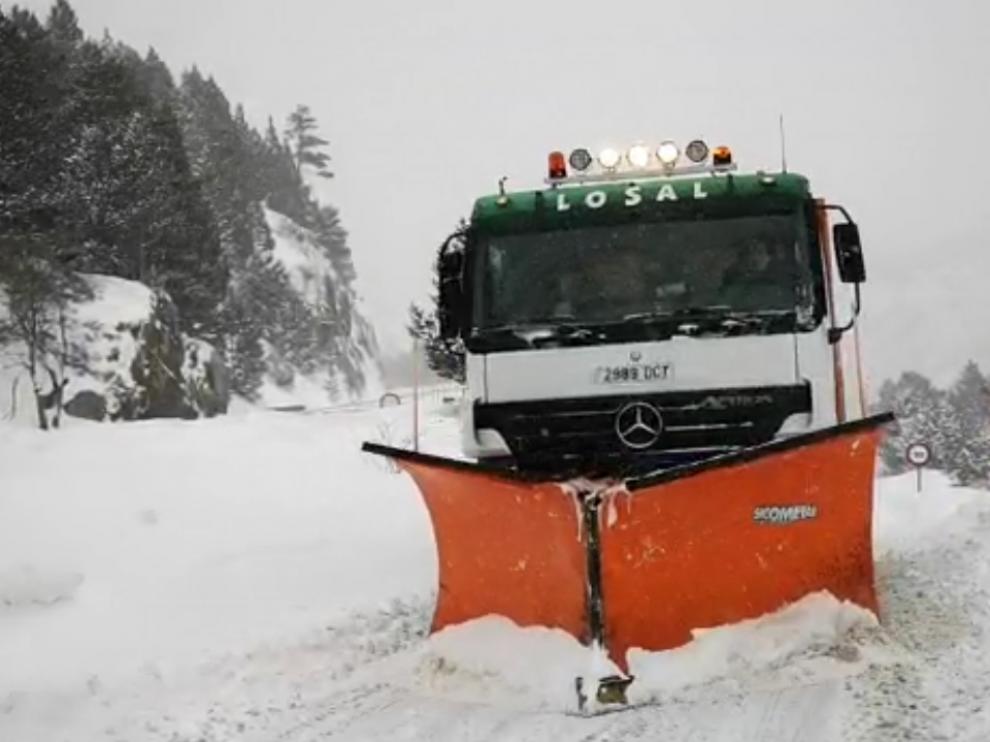 La máquina quitanieves despeja la carretera para dar paso a los vehículos que han abandonado el complejo turístico