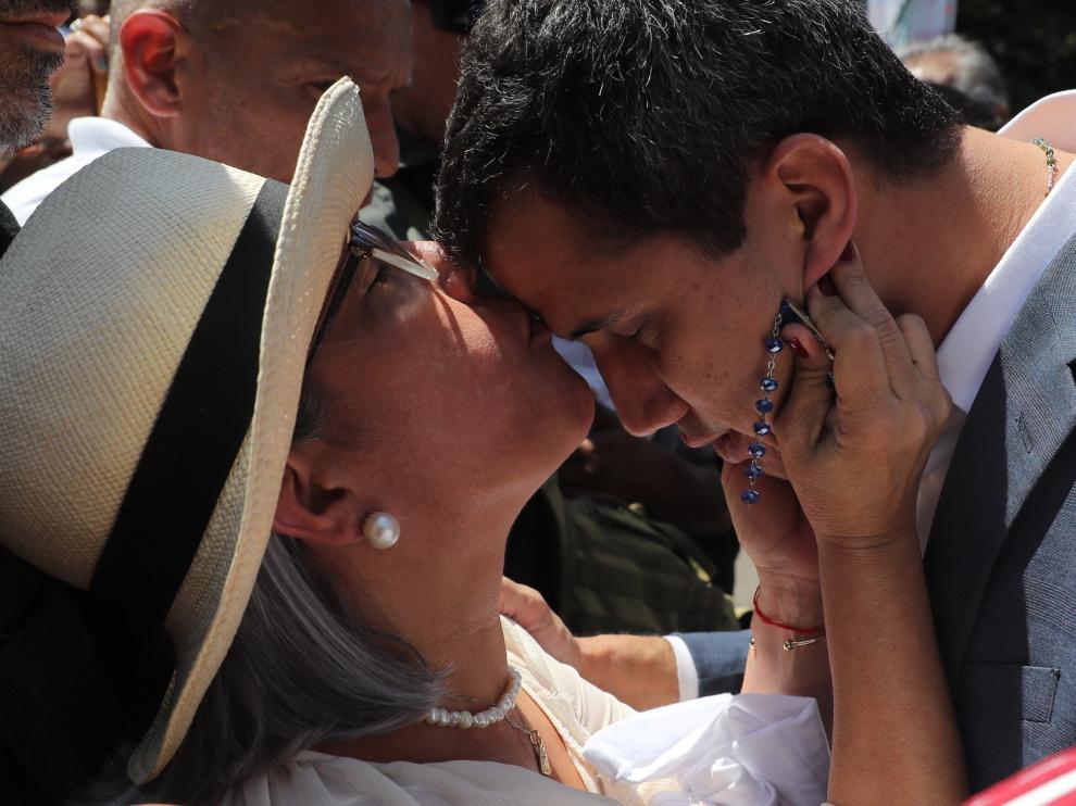 El presidente de la Asamblea Nacional de Venezuela, Juan Guaidó (d), recibe un beso de su madre, Norka Márquez, antes de hablar ante los asistentes a una manifestación en su apoyo y en contra del presidente de Venezuela, Nicolás Maduro, este sábado, en Caracas (Venezuela).