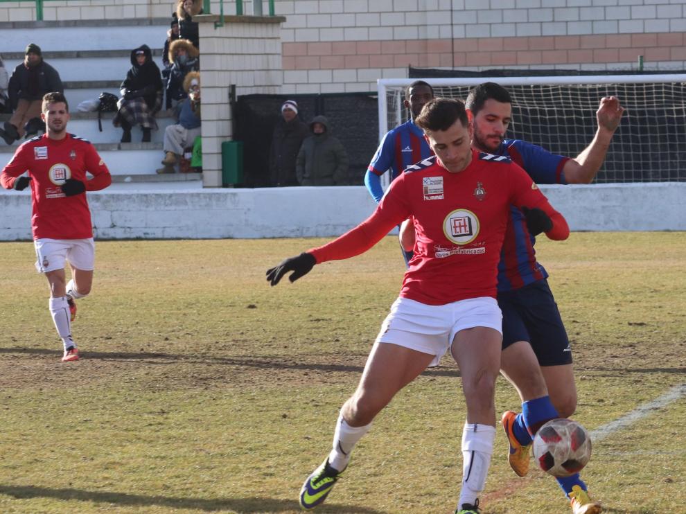 Un jugador del Calamocha pugna un balón ante la presión de un rival del Villanueva.