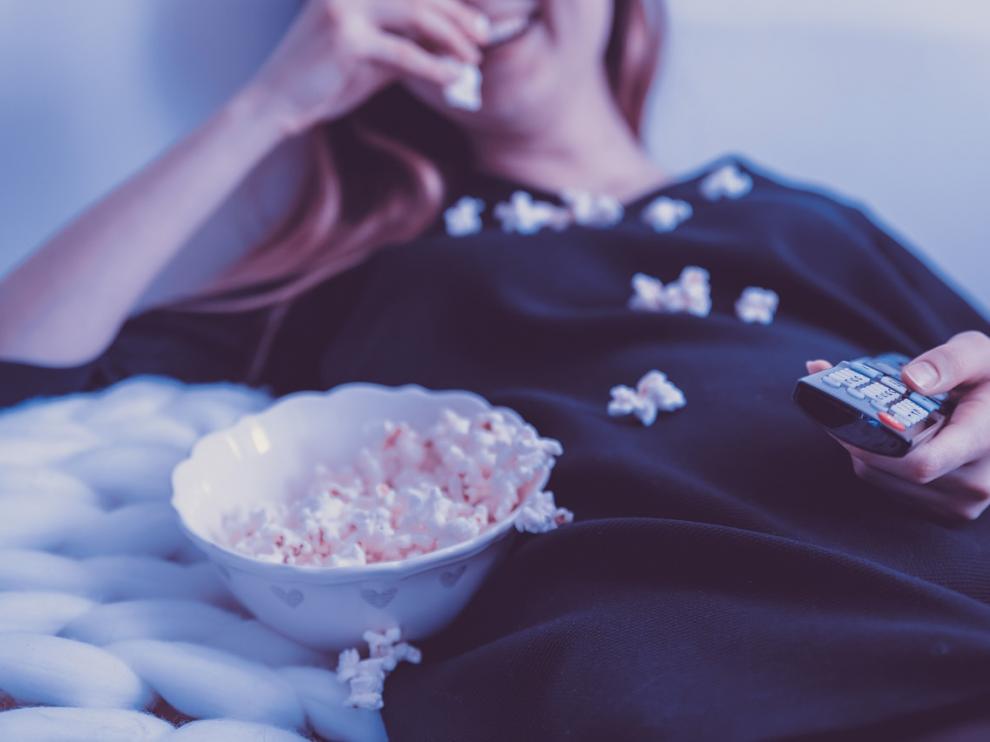 Una mujer disfrutando de la programación de televisión