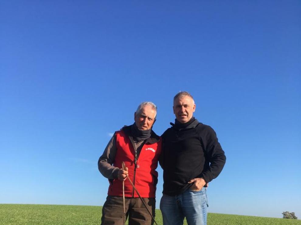 El criador Julián Oliván, de rojo, y Emiliano Rodríguez, el conductor del perro, junto a Colungo del Somontano.