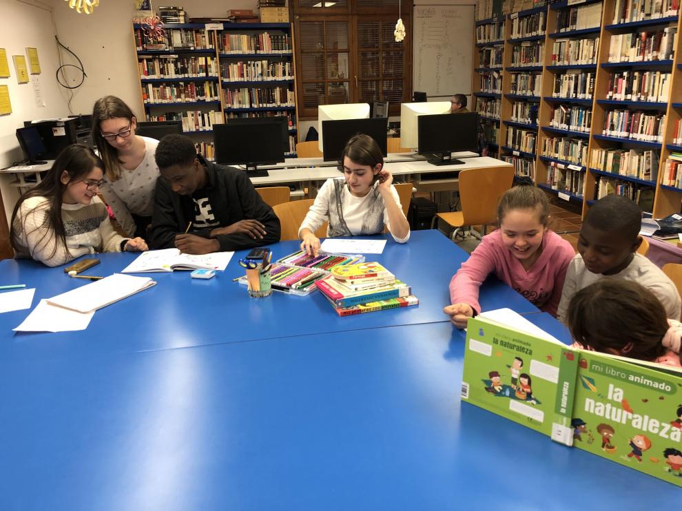 Niños de Fonz enseñan a leer y a escribir en la biblioteca a inmigrantes.