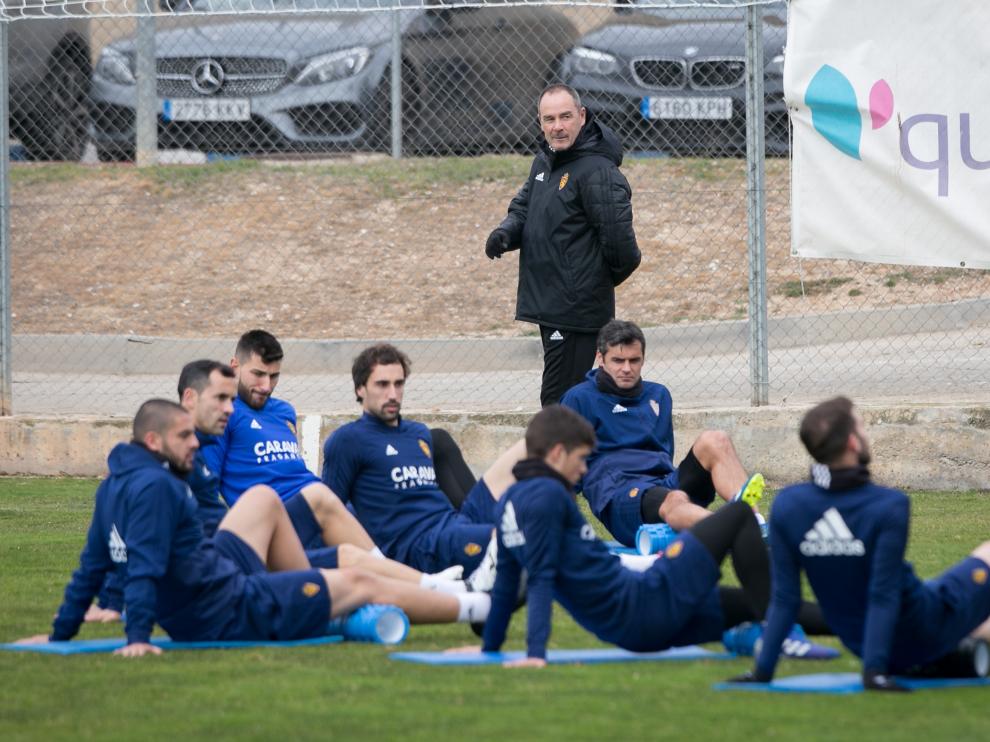 La plantilla del Zaragoza, bajo la mirada de Victor Fernández, estira en el entrenamiento de ayer en la Ciudad Deportiva.