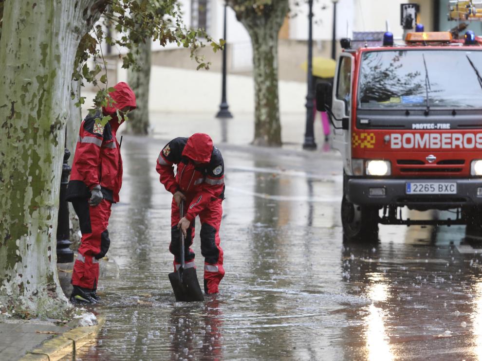 Bomberos de Huesca desatascando un desagüe durante una tromba