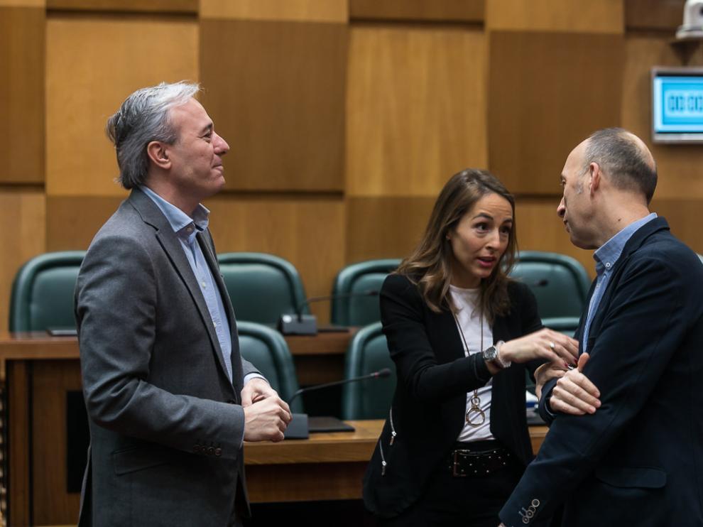 El portavoz del PP, Jorge Azcón, y la edil María Navarro, conversan este viernes con el portavoz de CHA, Carmelo Asensio.