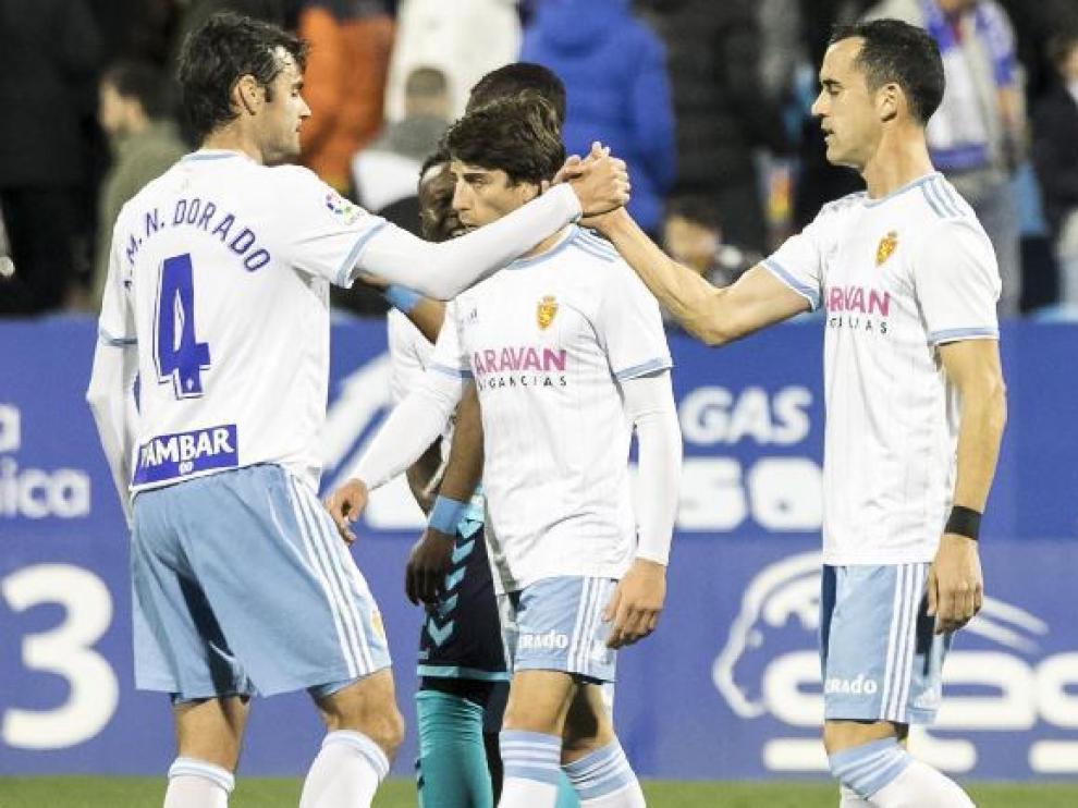 Dorado (4) saluda a Linares (7) al término del partido de este sábado entre el Real Zaragoza y el Albacete en La Romareda. Ambos, refuerzos de invierno, son los últimos en debutar con el equipo esta temporada.