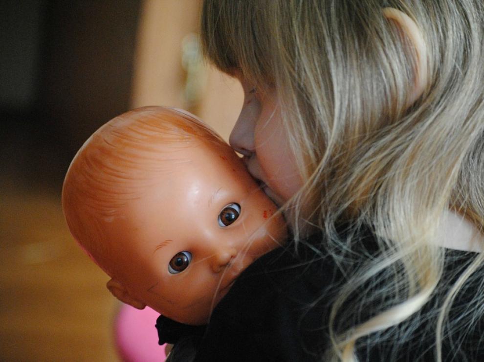Una niña juega con su muñeca