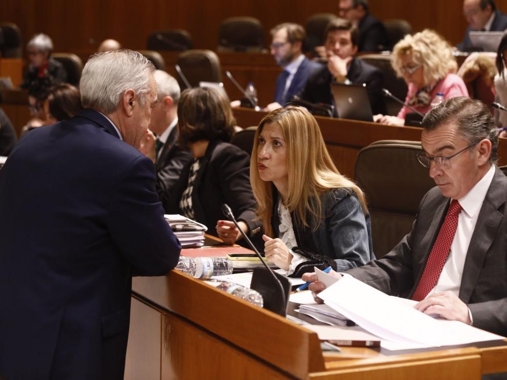 Los portavoces del PSOE y PP, Javier Sada y Mar Vaquero, conversan en el pleno de las Cortes, este jueves.