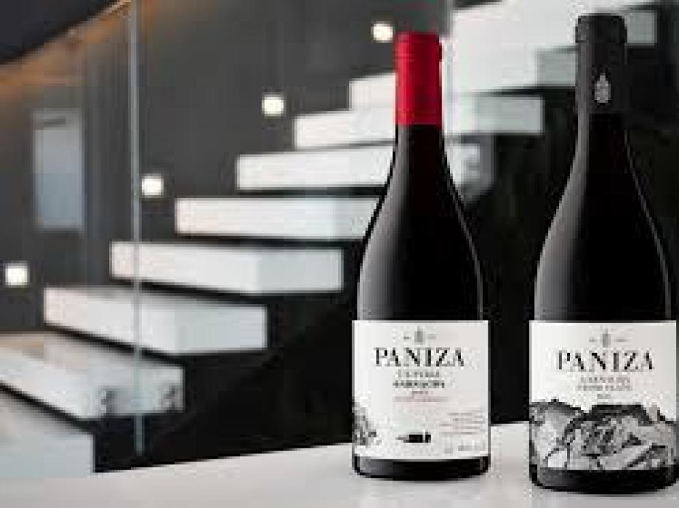 Vinos de Bodegas Paniza con las instalaciones de la nueva bodega al fondo.