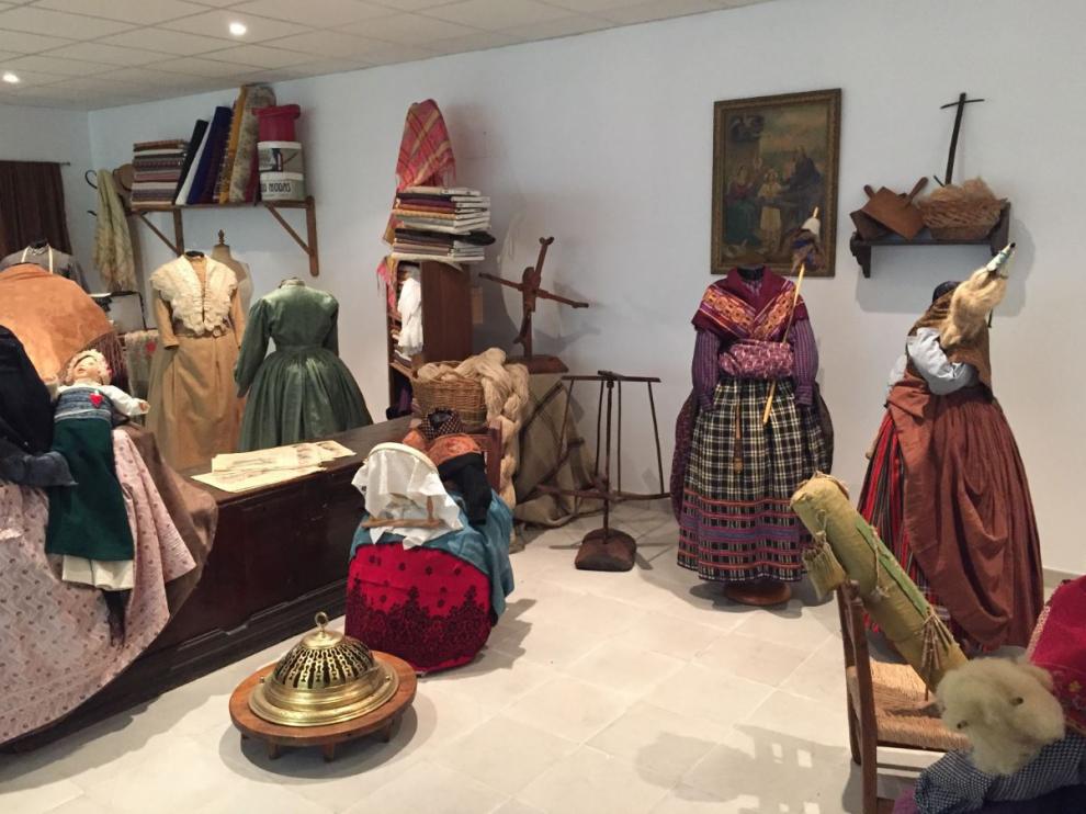 Espacio Indumentaria de Valdealgorfa. En primer plano, una escena de hilanderas, con los demoré y las devanaderas para hacer madejas y ovillos.