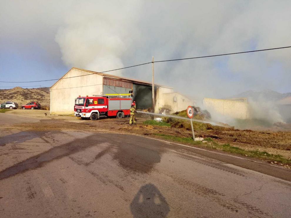 Los bomberos han sacado al exterior un centenar de balas de paja que estaban ardiendo.