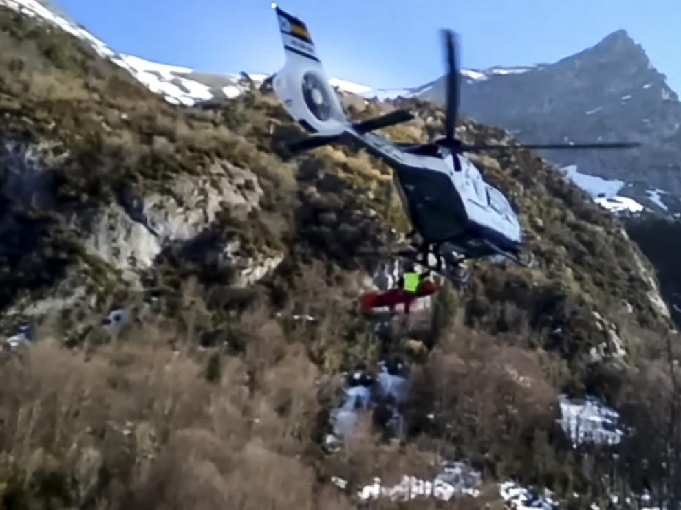 Una imagen de la camilla con el herido siendo izada al helicóptero