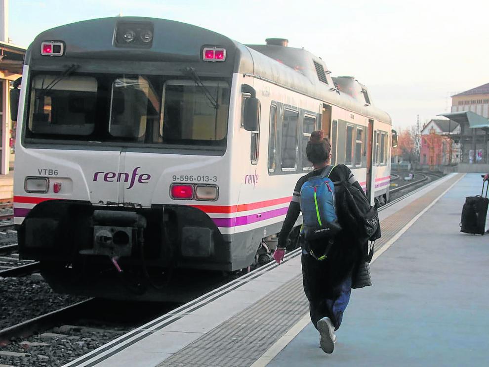 Dos usuarios en la estación intermodal de Huesca, accediendo ayer al ‘tamagotchi’ para viajar hasta Zaragoza.