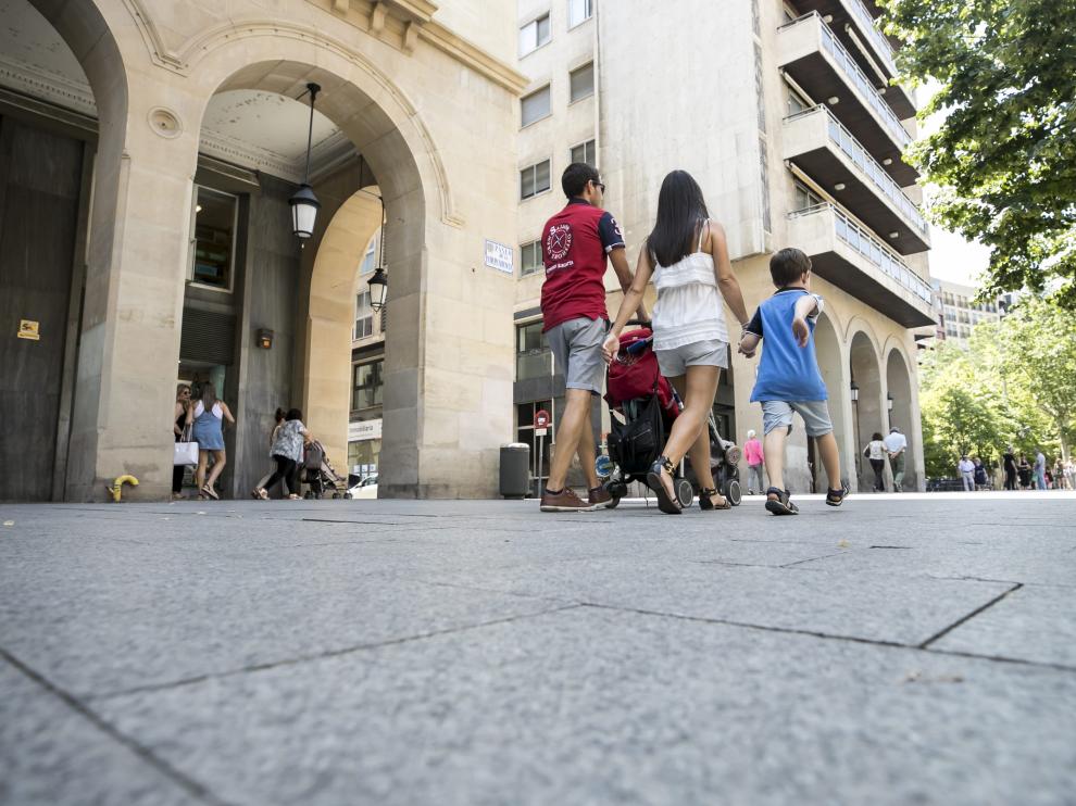 Una pareja pasea con sus hijos por Zaragoza.
