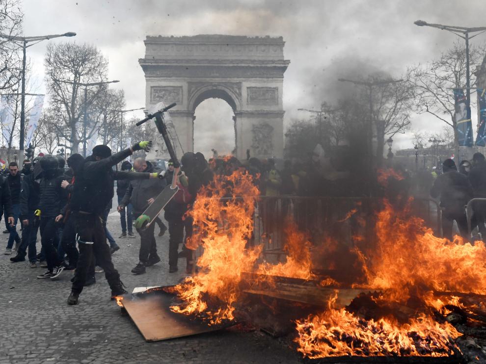Paris (France), 16/03/2019.- A protester from the 'Gilets Jaunes' (Yellow Vests) lights a yellow flare near the Champs Elysees during the 'Act XVIII' demonstration (the 18th consecutive national protest on a Saturday) in Paris, France, 16 March 2019. The so-called 'gilets jaunes' (yellow vests) is a grassroots protest movement with supporters from a wide span of the political spectrum, that originally started with protest across the nation in late 2018 against high fuel prices. The movement in the meantime also protests the French government's tax reforms, the increasing costs of living and some even call for the resignation of French President Emmanuel Macron (Protestas, Francia) EFE/EPA/JULIEN DE ROSA Yellow vests protest against police violence in Paris