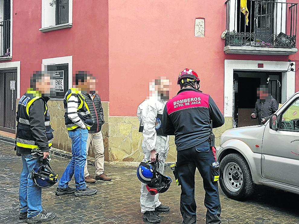 Bomberos y agentes de la Policía Científica acceden al edificio para la investigación.