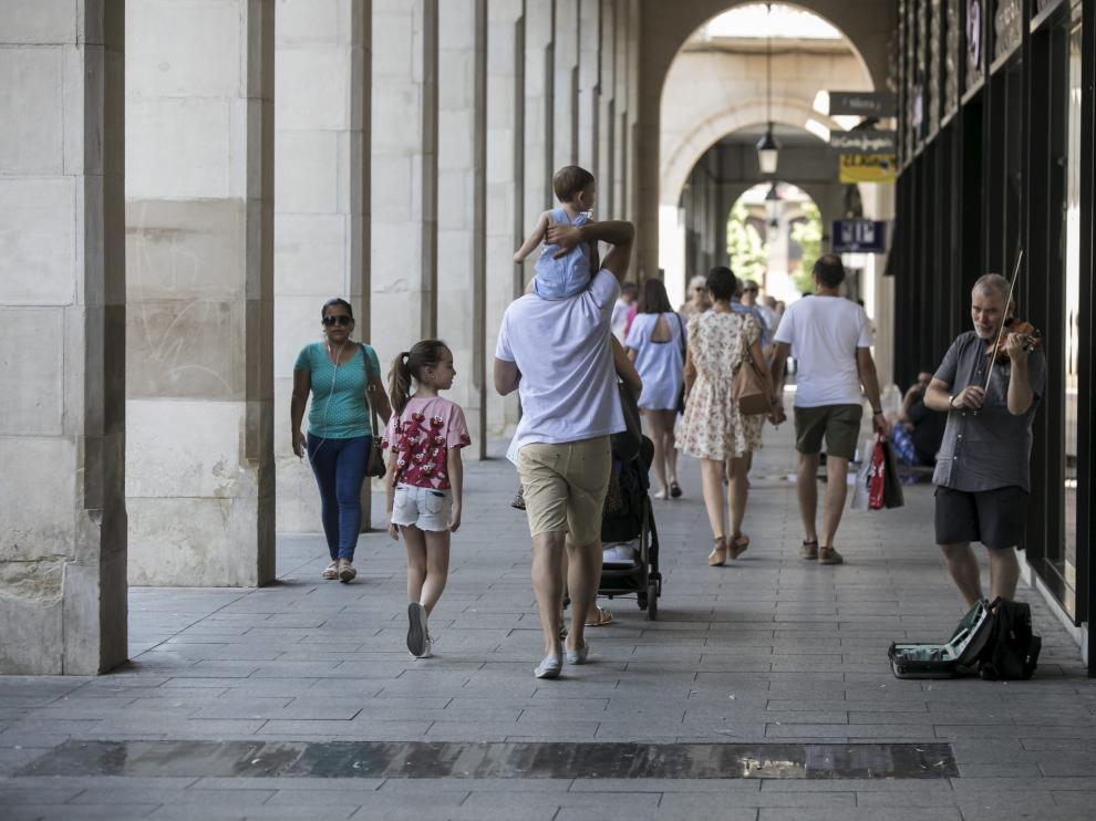 Un padre pasea con sus hijos por Zaragoza.