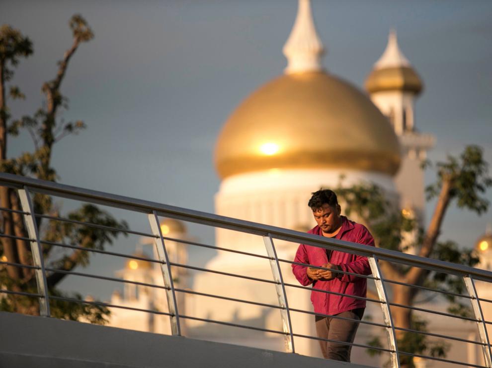 Un hombre camina frente a la mezquita del sultán Omar Ali Saifuddien, en Bandar Seri Begawan, Brunéi.