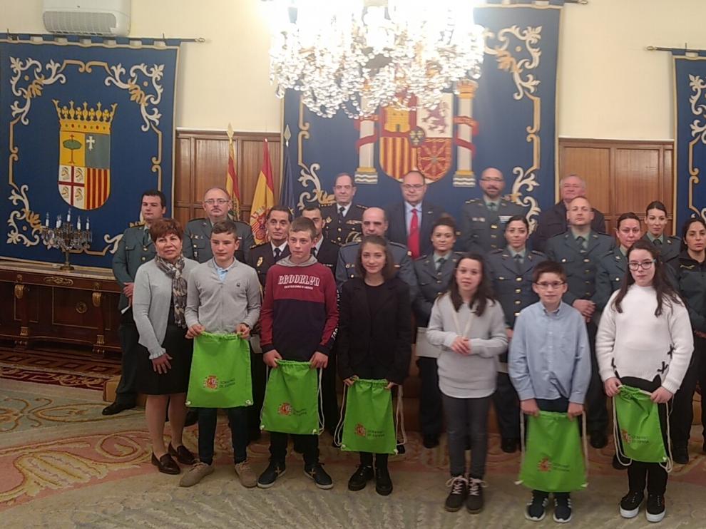 Foto de familia con niños del CRA de Rubielos, los agentes galardonados y las autoridades.