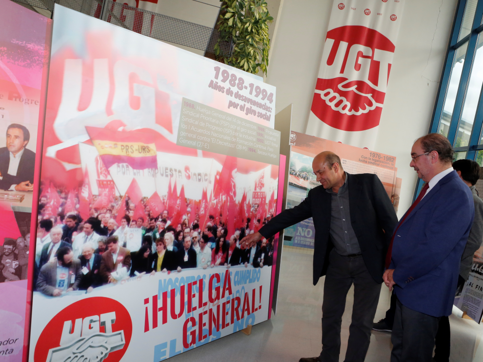 El secretario general de UGT Aragón, Daniel Alastuey, muestra a Javier Lambán, presidente del Gobierno de Aragón, imágenes de algunas de las huelgas más representativas vividas en España.