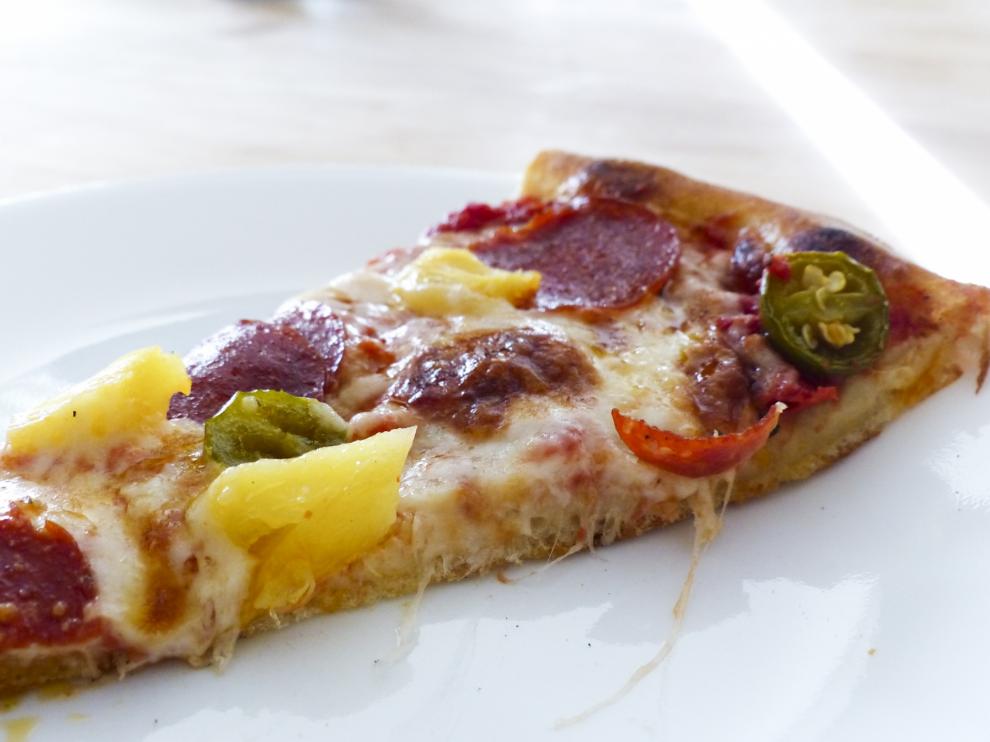 Sí, esto es una foto de trozo de pizza con piña.