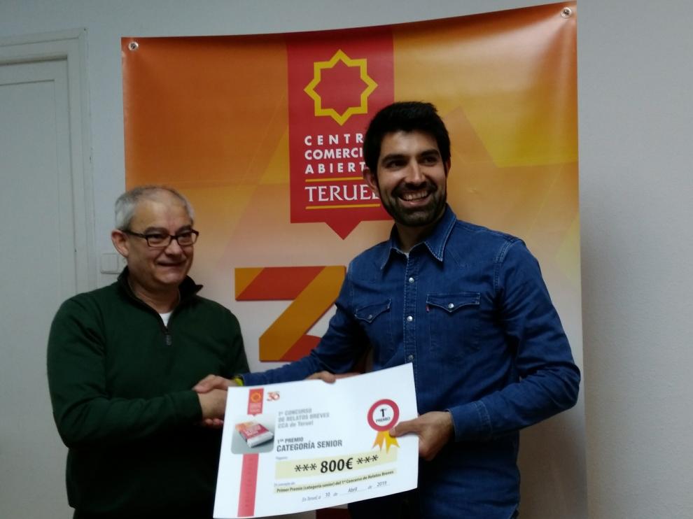 javier Gómez, del Centro Comercial Abierto, entrega el premio de relatos a Javier Lizaga.