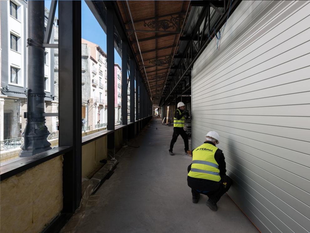 Varios operarios colocando ya las persianas de la empresa aragonesa Ferpal en el Mercado Central de Zaragoza