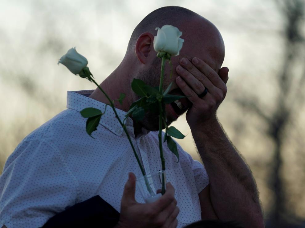 Un superviviente del tiroteo llora ante el memorial que recuerda a las víctimas