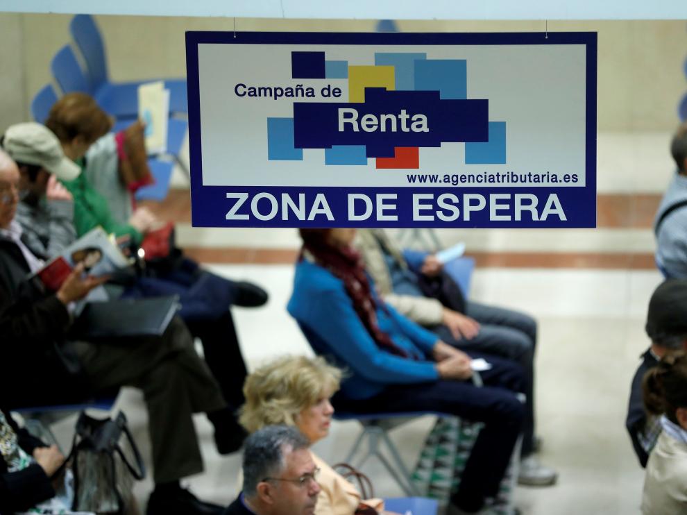 Unos ciudadanos esperan en una delegación madrileña para ser elaborar la declaración de la renta en la campaña pasada.