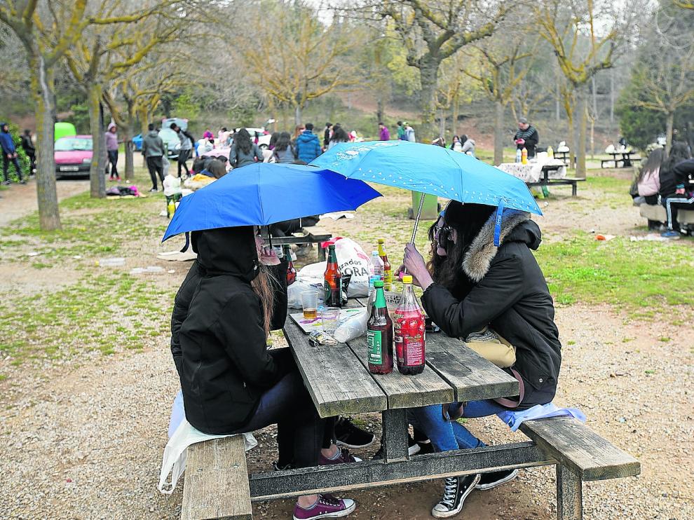 La lluvia obligó a sacar el paraguas en la Fuente Cerrada, el paraje preferido por los turistas para celebrar la fiesta.