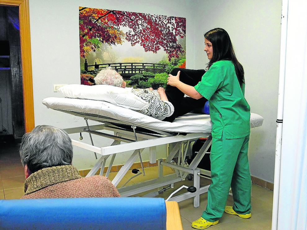 Una cuidadora ayuda a una anciana en el centro de día de Afami en Miranda de Ebro