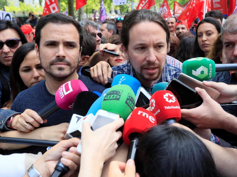 El secretario general de Podemos, Pablo Iglesias (c), en presencia del líder de IU, Alberto Garzón (i), hace declaraciones a los medios antes de participar en la manifestación convocada en Madrid con motivo del Primero de Mayo
