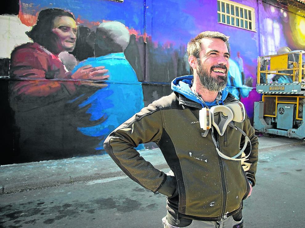 El zaragozano Hugo Casanova, ante su mural en una antigua nave donde tenían lugar las verbenas.
