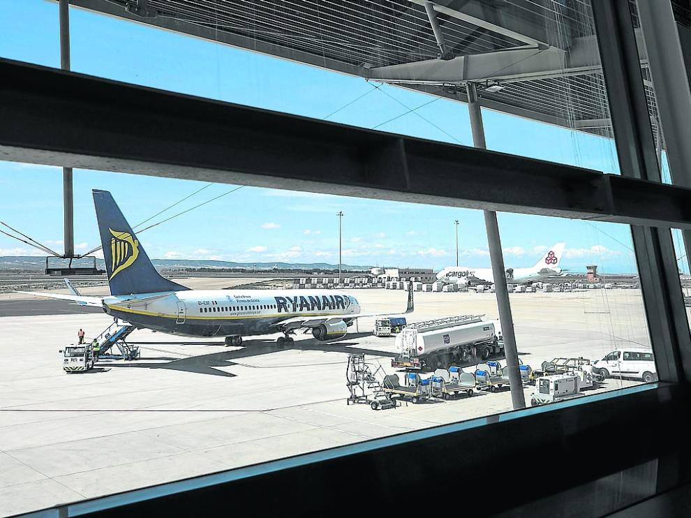 Un avión de pasajeros y otro de carga en el aeropuerto de Zaragoza. Al fondo, la torre de control.