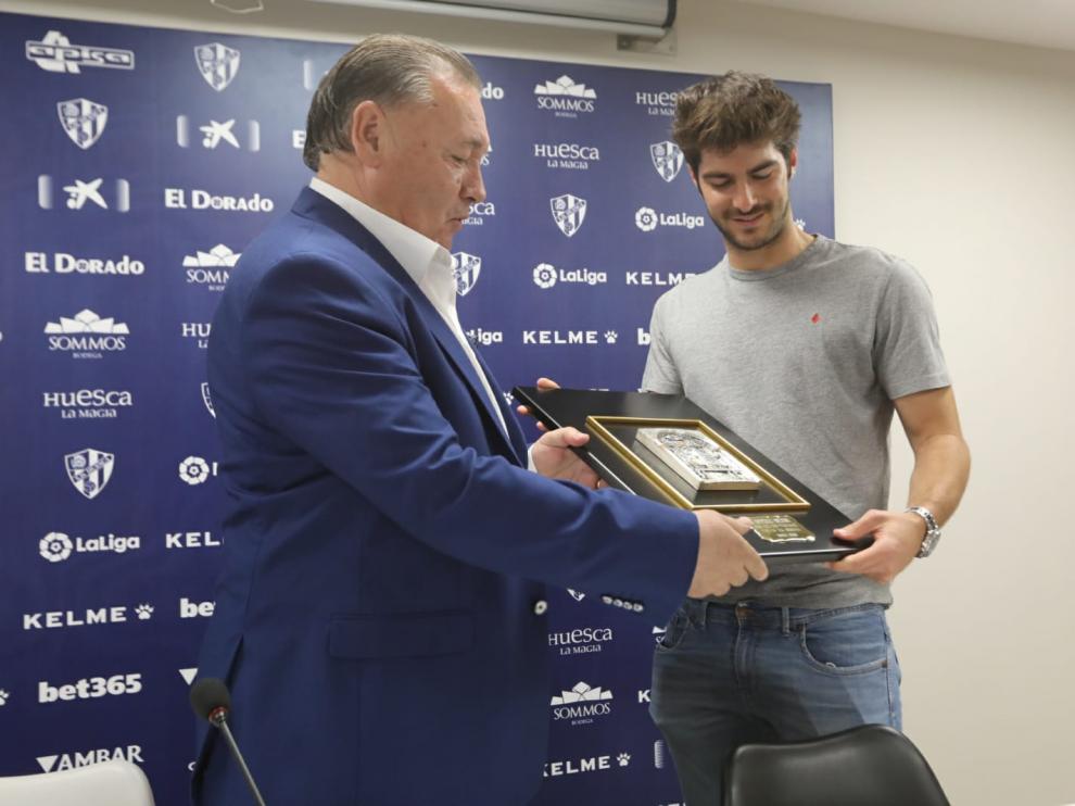 El presidente de la SD Huesca , Agustín Lasaosa, le entrega una placa conmemorativa a Gonzalo Melero.