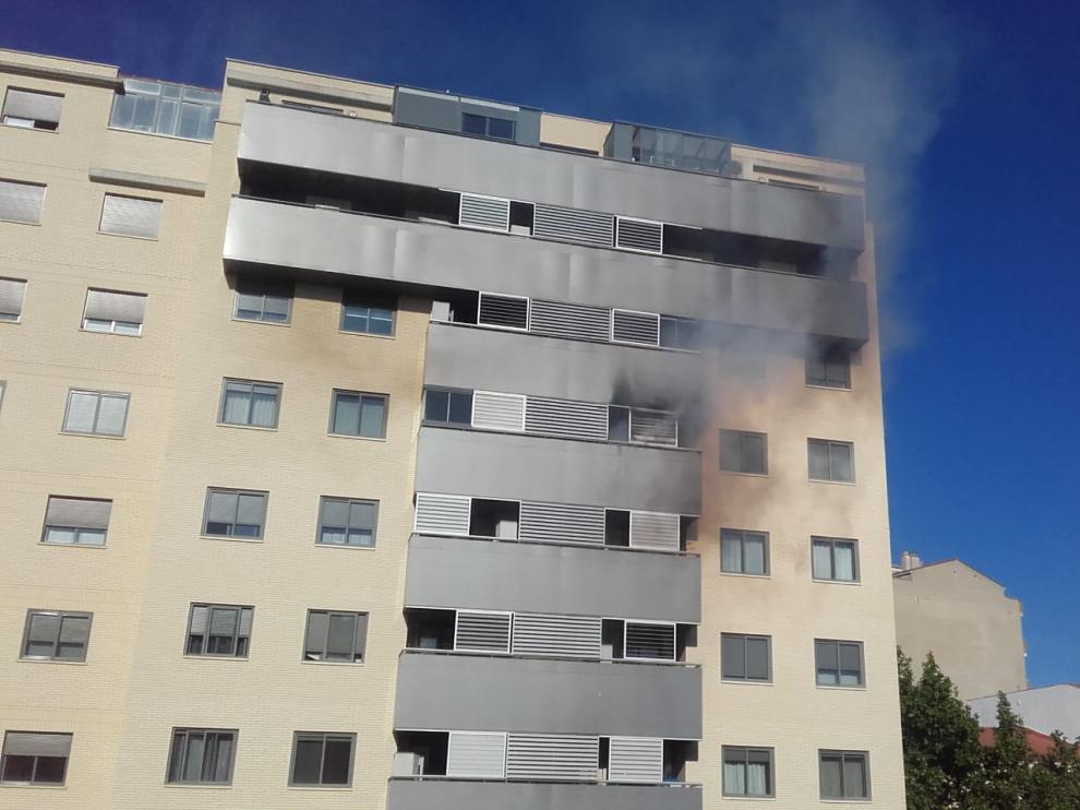 Humo negro saliendo de la terraza de la vivienda.