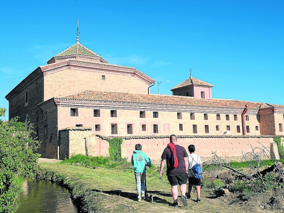 Tres niños contemplan el antiguo convento de Gea de Albarracín, ahora convertido en residencia.
